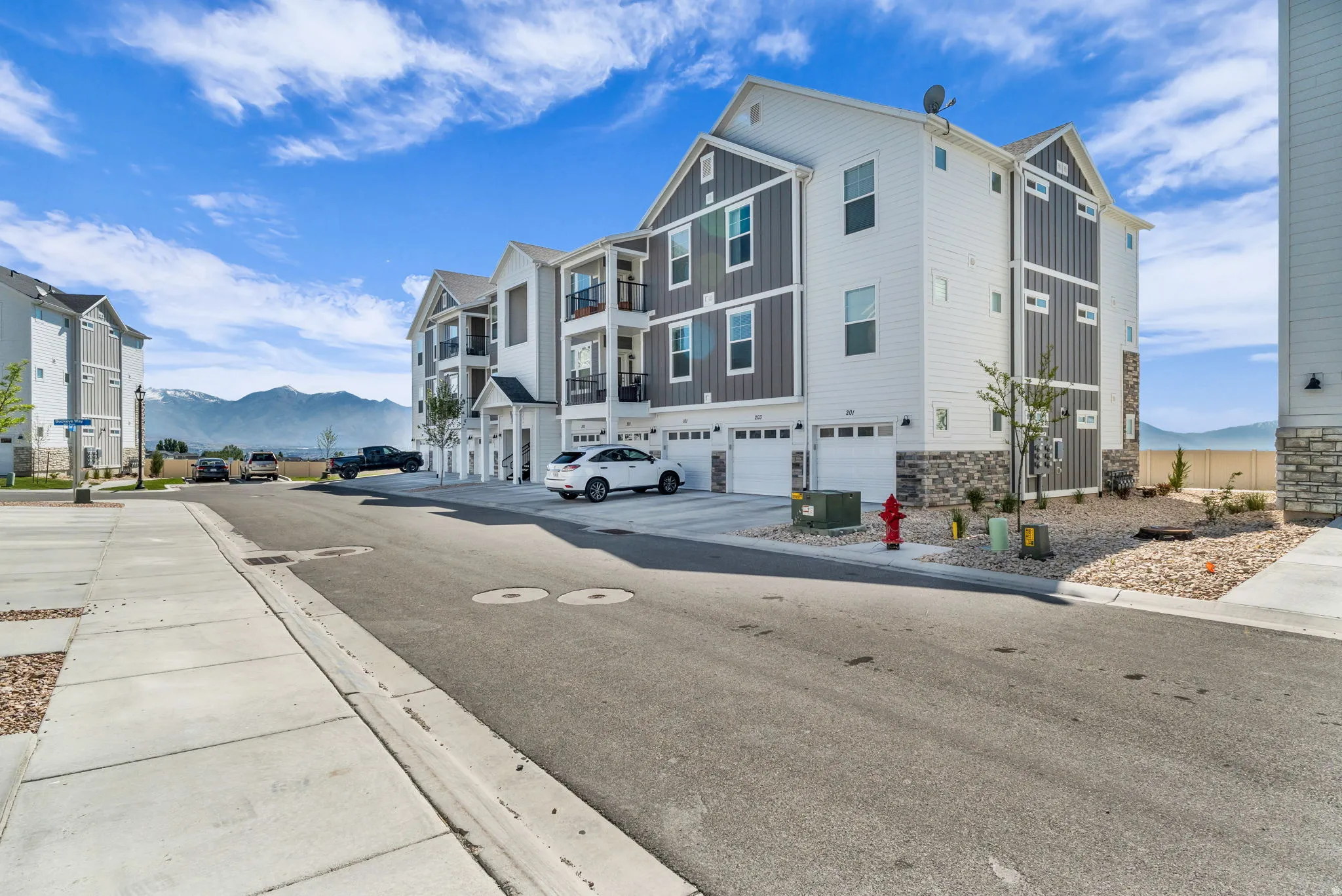 Modern townhome exteriors featuring white siding and contrasting dark gray paneling