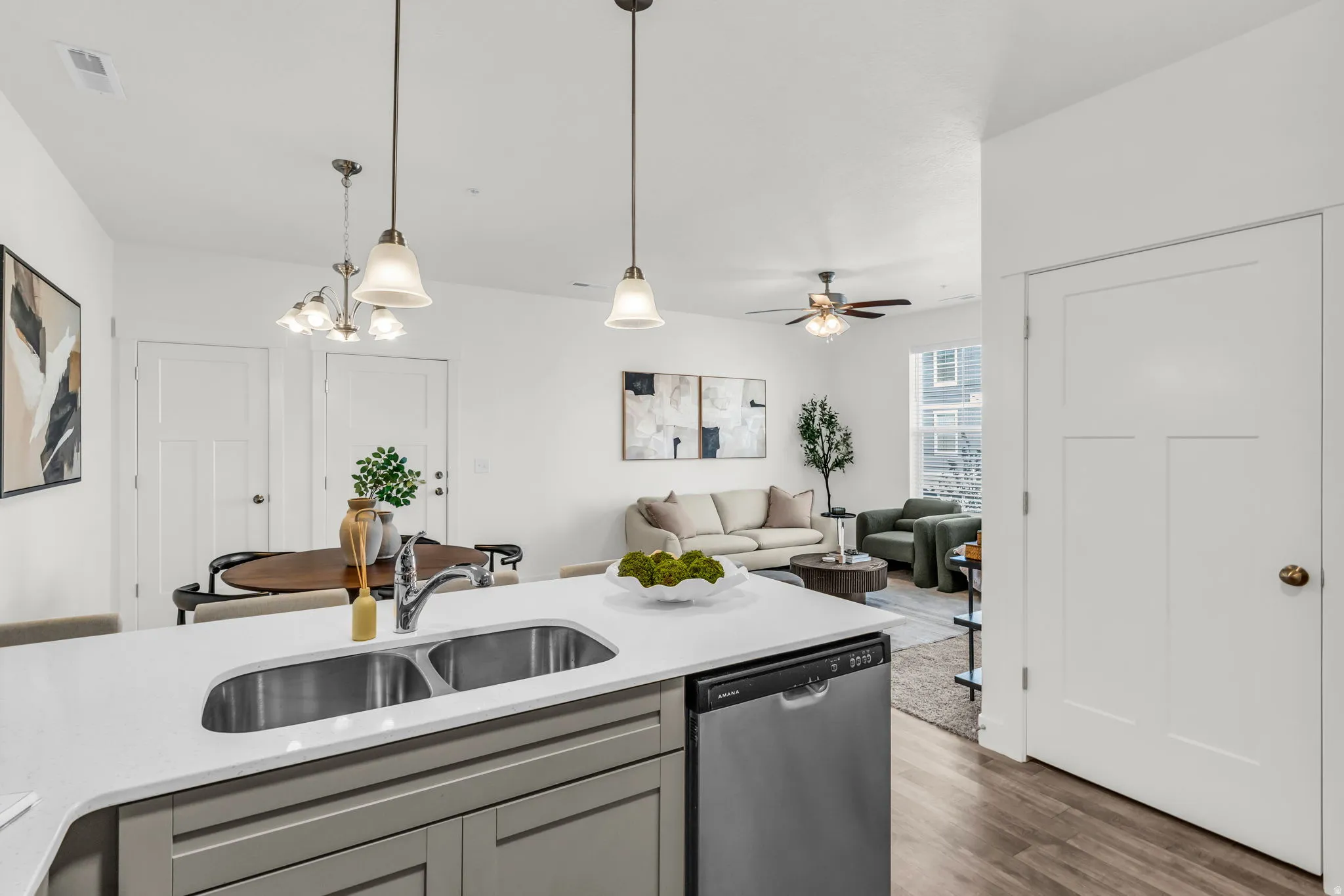 Kitchen island featuring a dual stainless steel sink and a built-in dishwasher