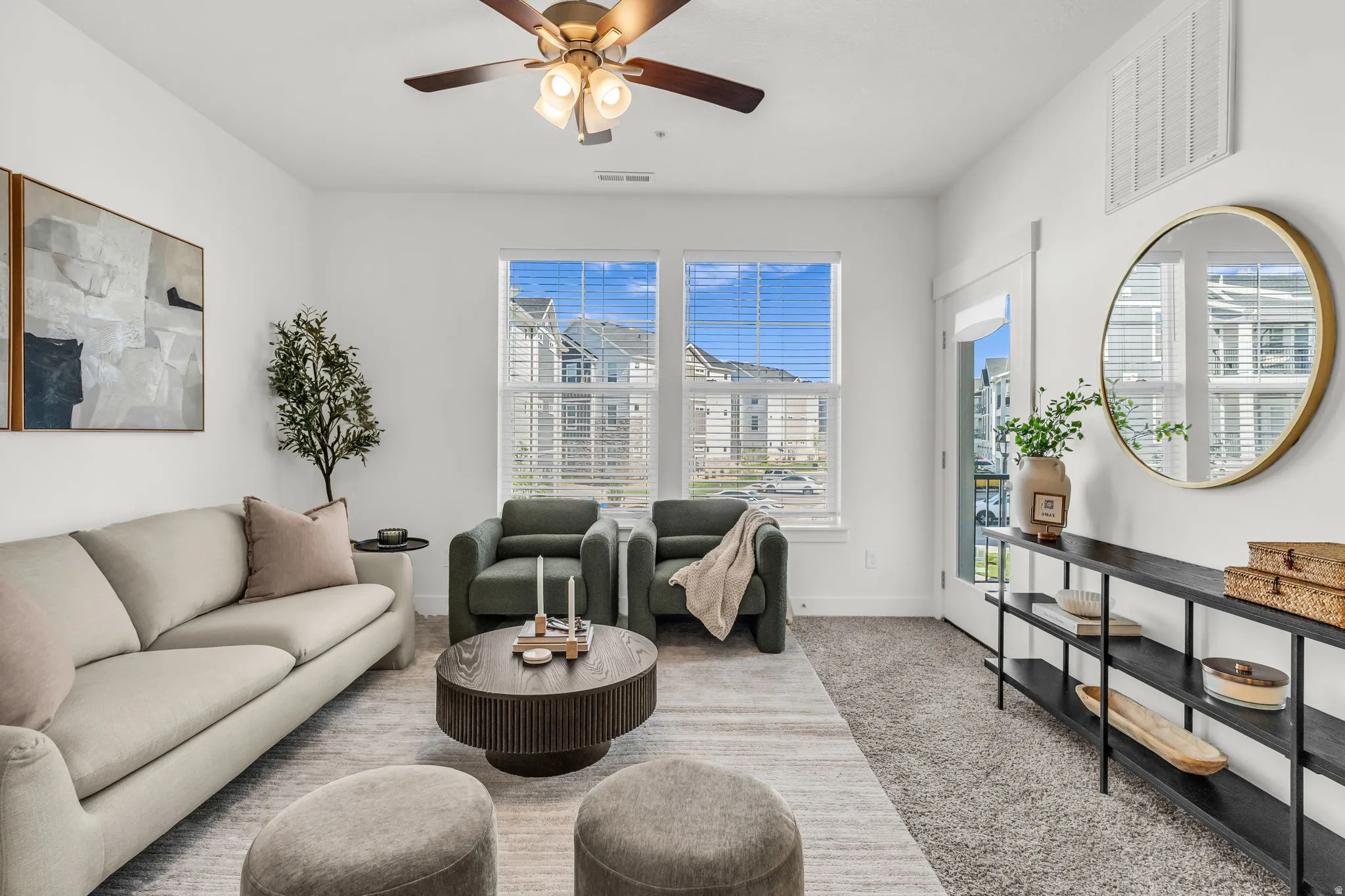 Living room featuring light gray carpet, white walls, and a ceiling fan with integrated lighting
