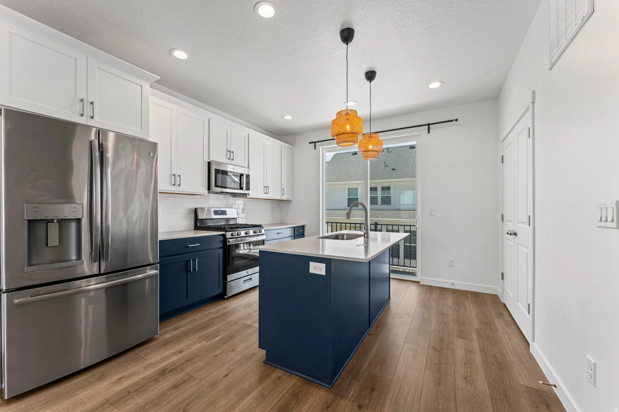 Modern kitchen featuring white upper cabinetry and contrasting blue lower cabinetry
