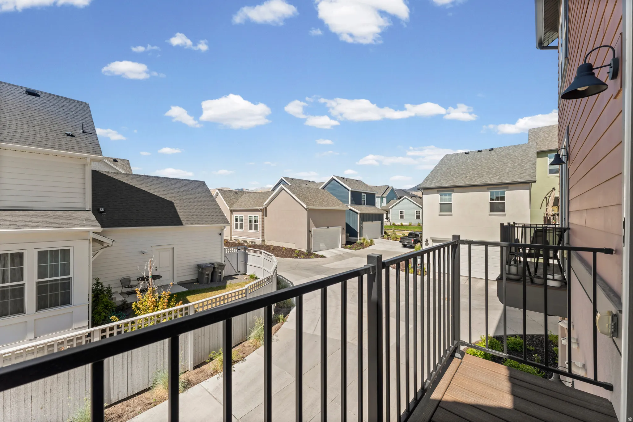 Private balcony featuring wood-finish decking and black metal railings