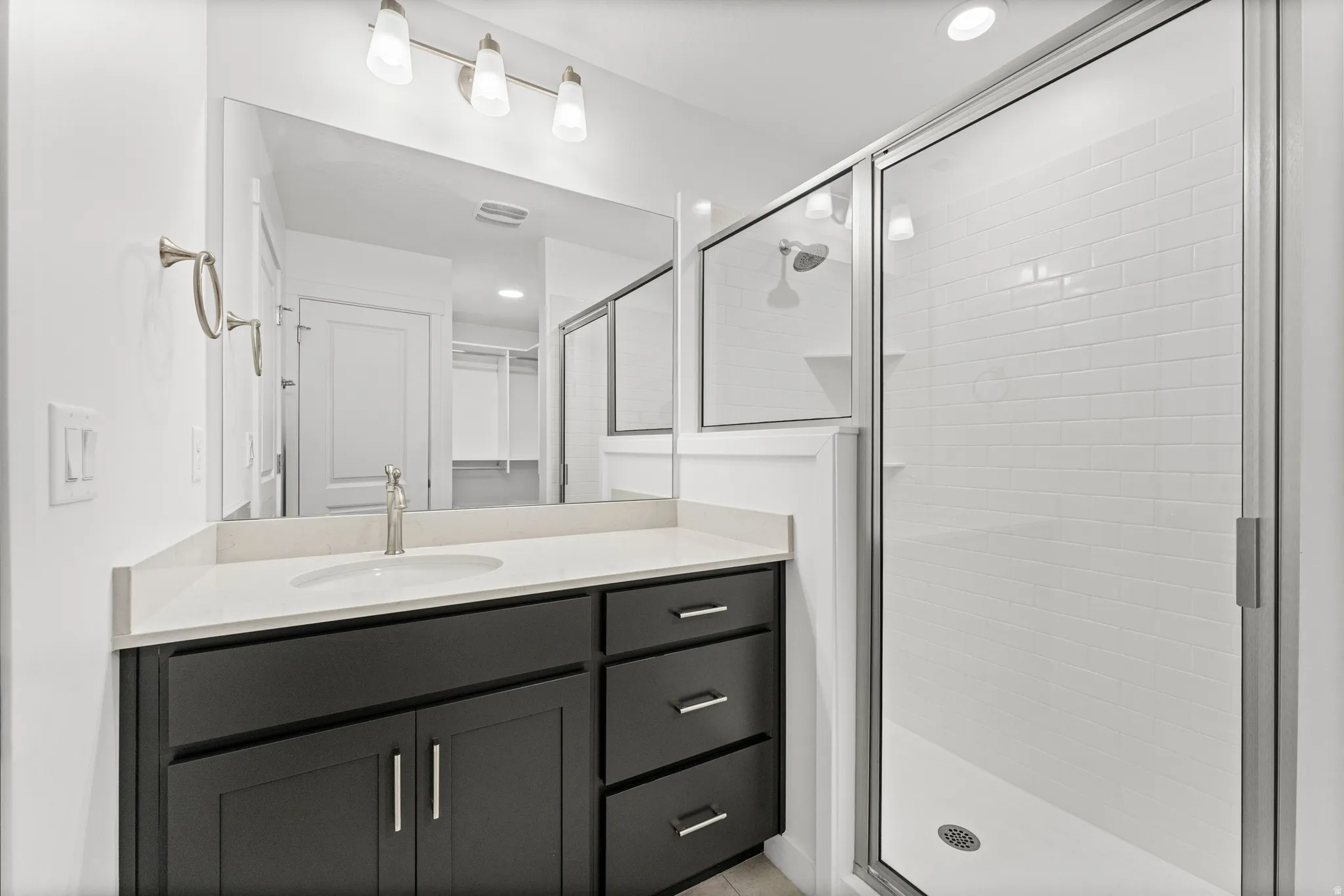 Contemporary bathroom featuring a dark wood-finish vanity with an integrated sink and light-toned countertop