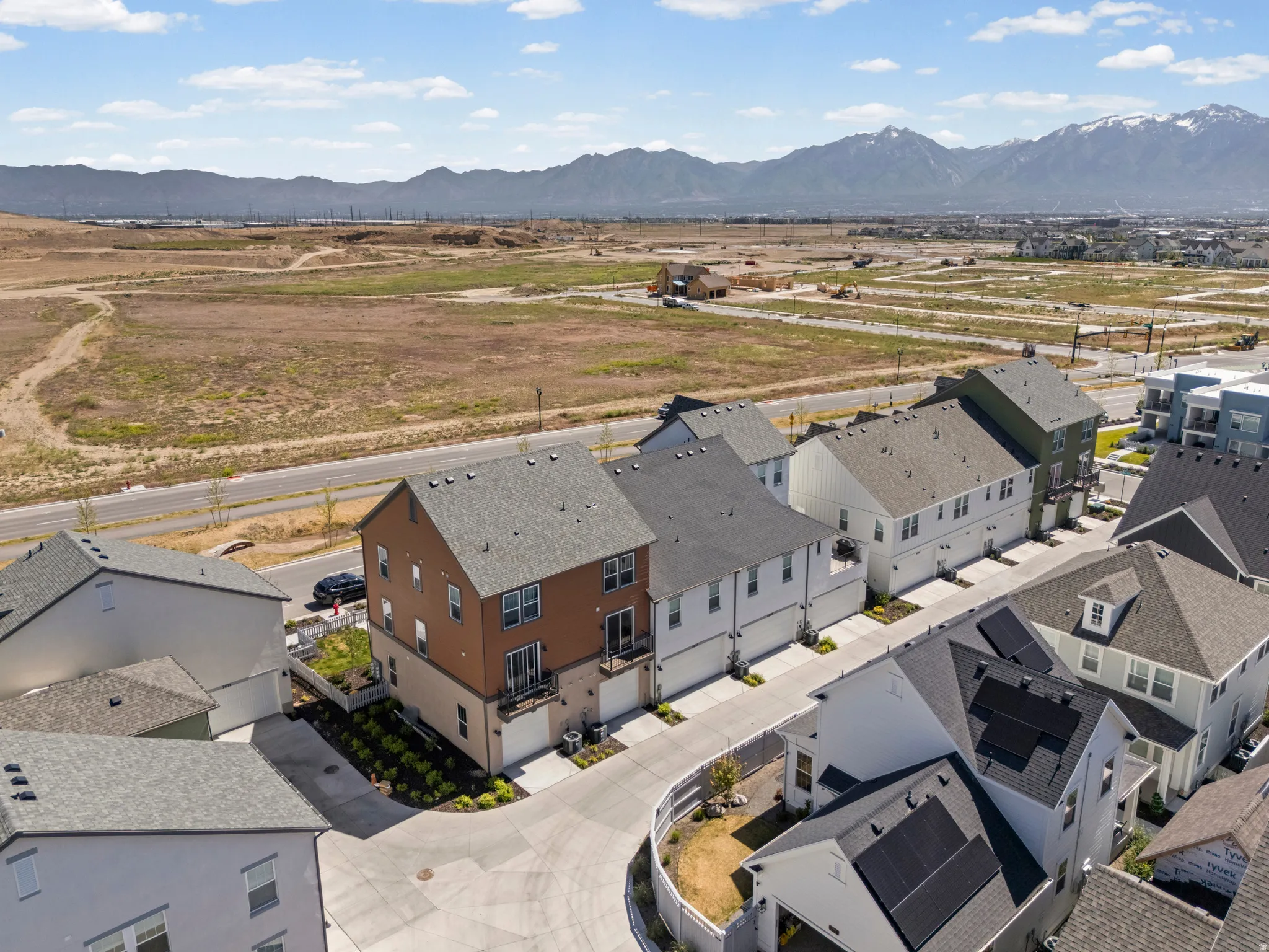 Aerial perspective showcasing a row of multi-story townhomes with varied exterior finishes