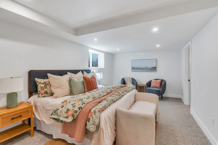 Recessed lighting illuminates this carpeted room featuring a window with blinds, white walls, and a white ceiling