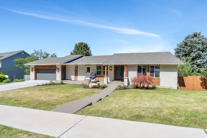 Contemporary ranch-style residence featuring a light brick facade and dark wood accents