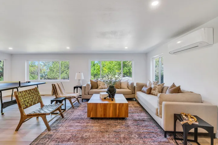 Spacious room featuring multiple large windows, recessed lighting, and wood-finish flooring