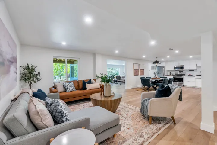 Spacious living area featuring light wood-finish flooring and recessed lighting