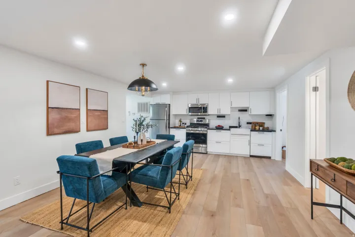 Open-concept dining area and kitchen featuring light wood-finish flooring
