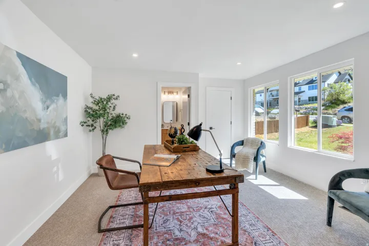 Bright room with recessed lighting and neutral carpeting
