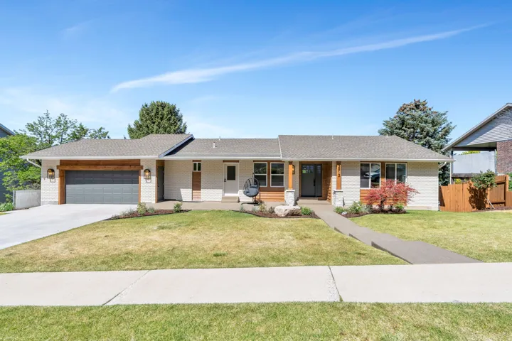 Ranch-style residence featuring a prominent two-car garage with a wood-finish header