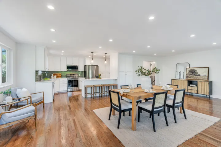 Open-concept living space featuring wood-finish flooring, recessed lighting, and white walls