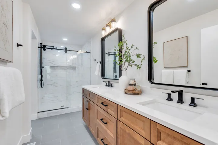 Dual vanity with white countertops, undermount sinks, and matte black fixtures