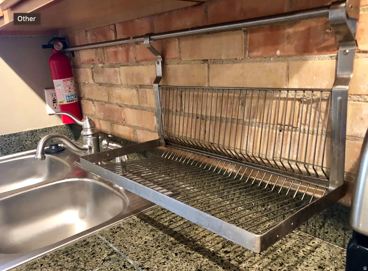 Integrated dish drying rack positioned above a stainless steel double basin sink with a chrome faucet