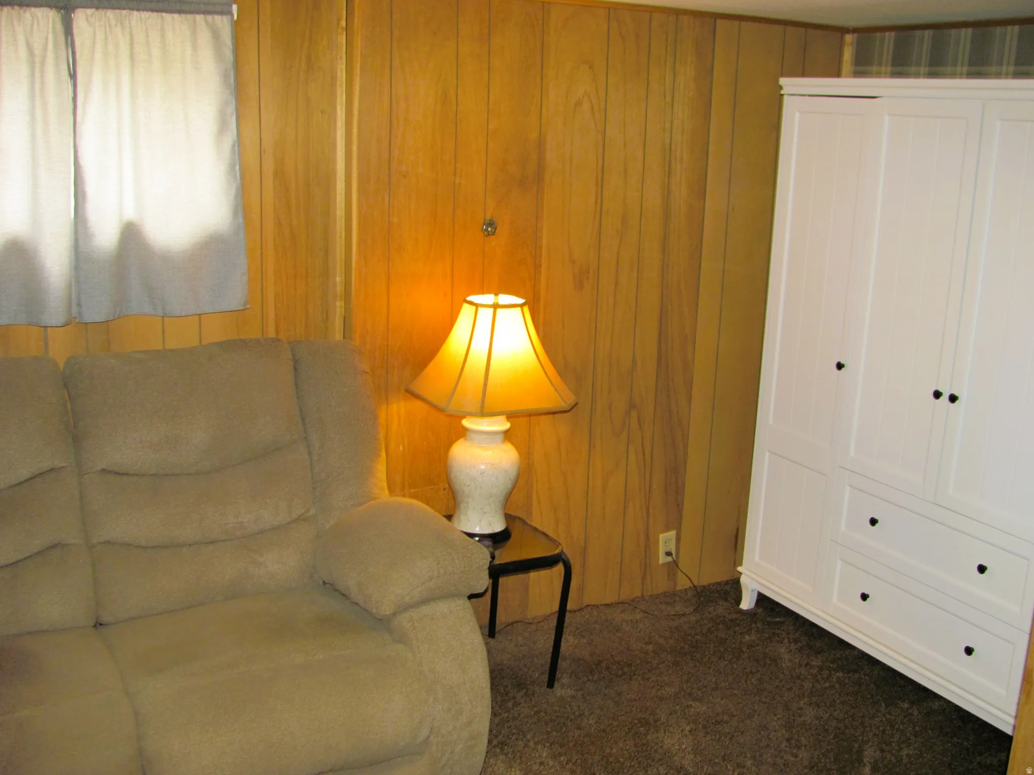 Interior space featuring vertical wood paneling and dark carpeting