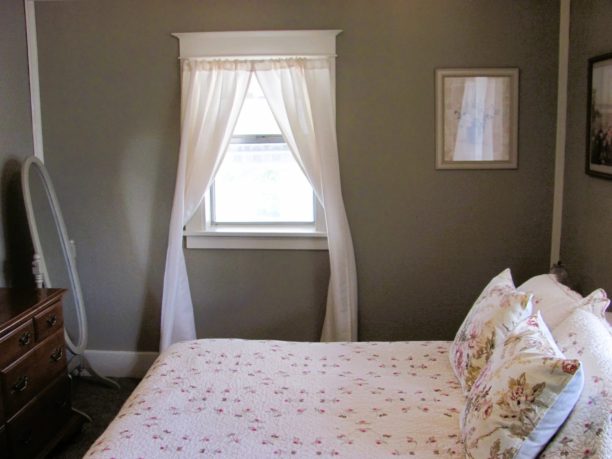 Room featuring a window with white trim, a decorative valance, and neutral wall paint