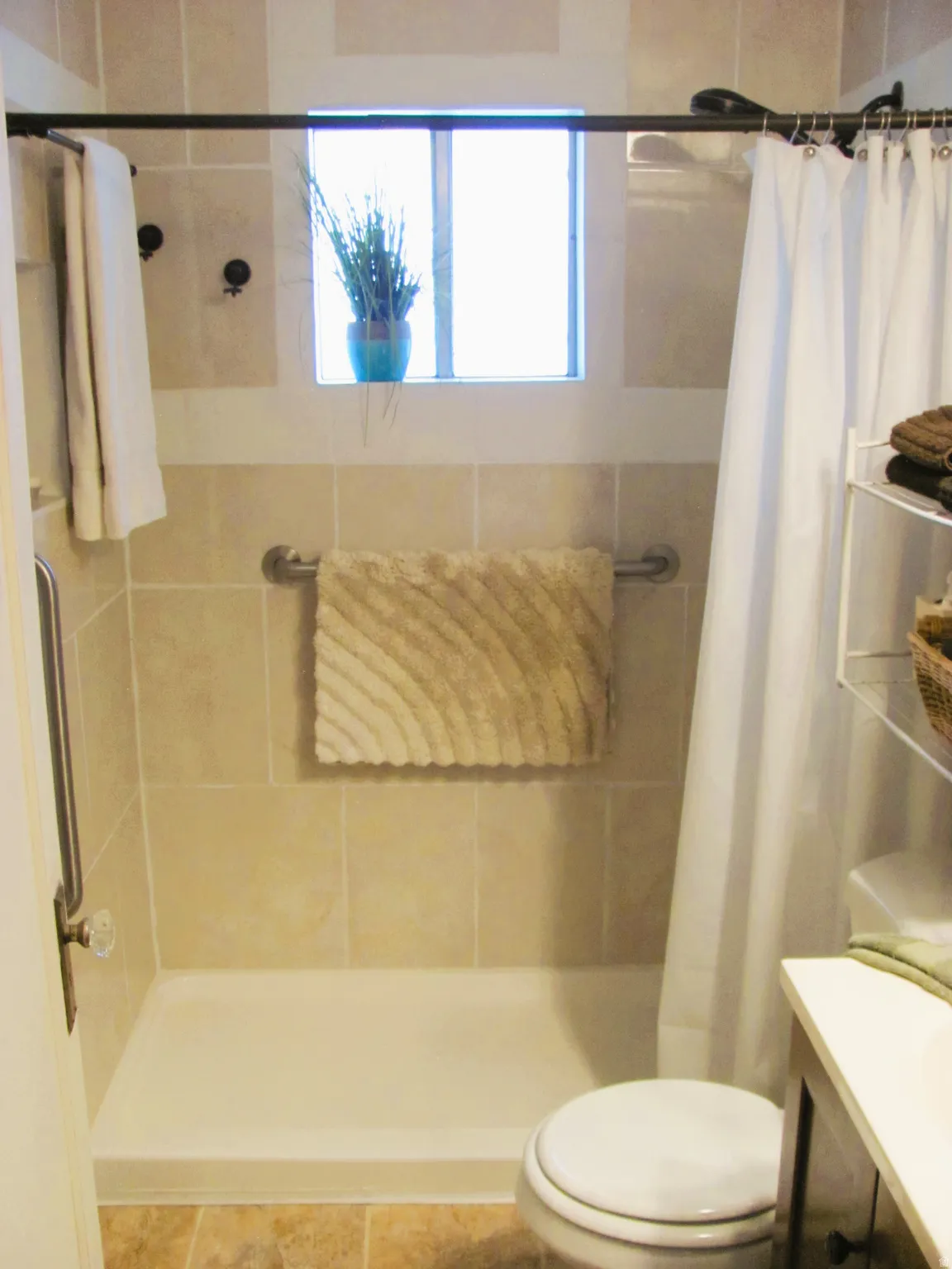 Tiled shower surround featuring a built-in window and grab bar
