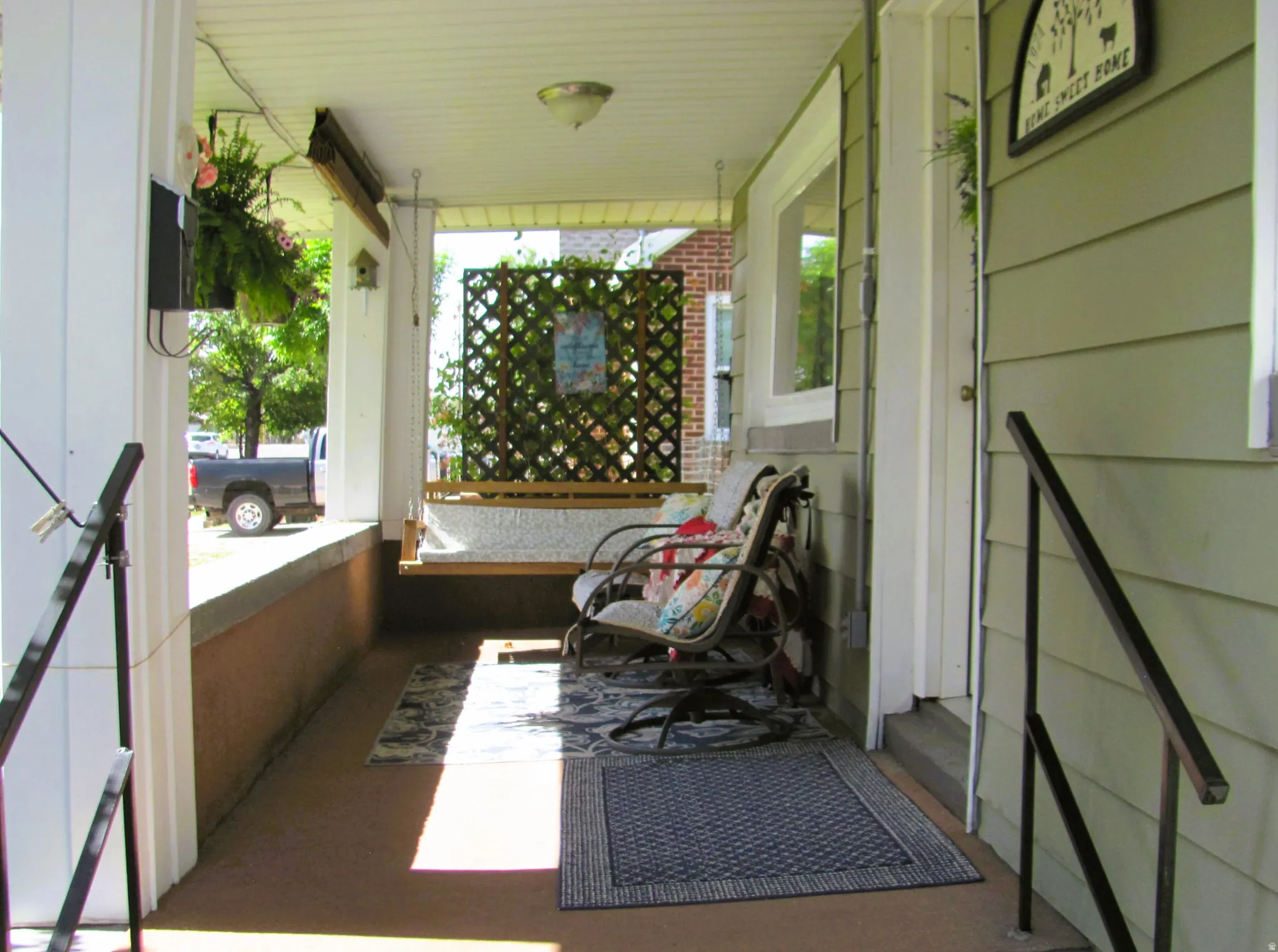 Covered front porch featuring a porch swing and painted floor
