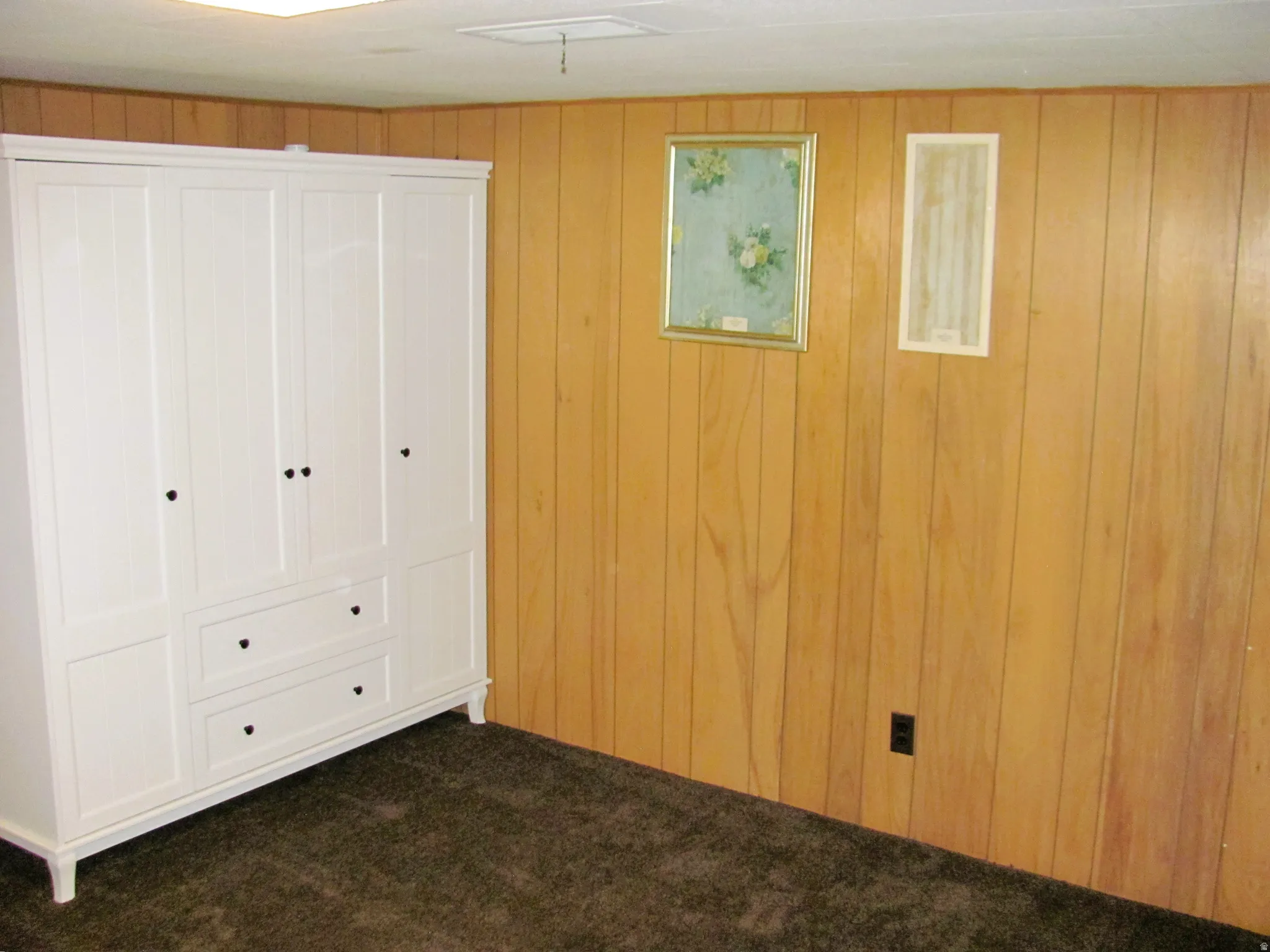 Vertical wood paneling with dark carpet flooring