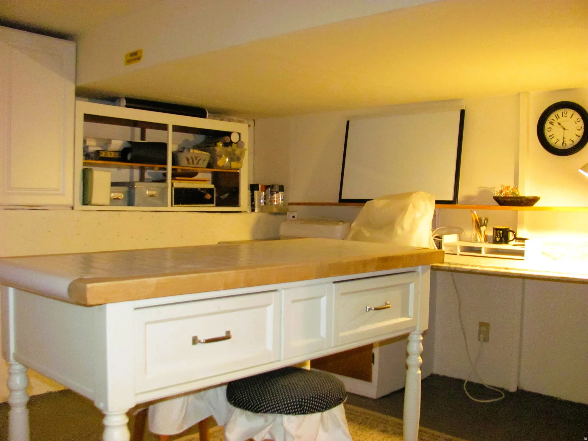 Butcher block island with white cabinetry and storage drawers, complemented by built-in wall shelving and an additional counter space