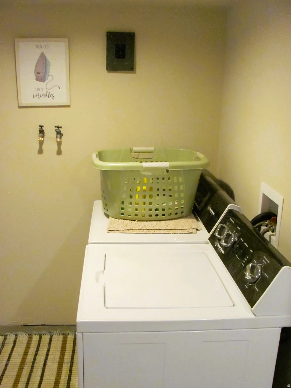 Dedicated laundry area featuring a white top-load washing machine and a black control panel dryer