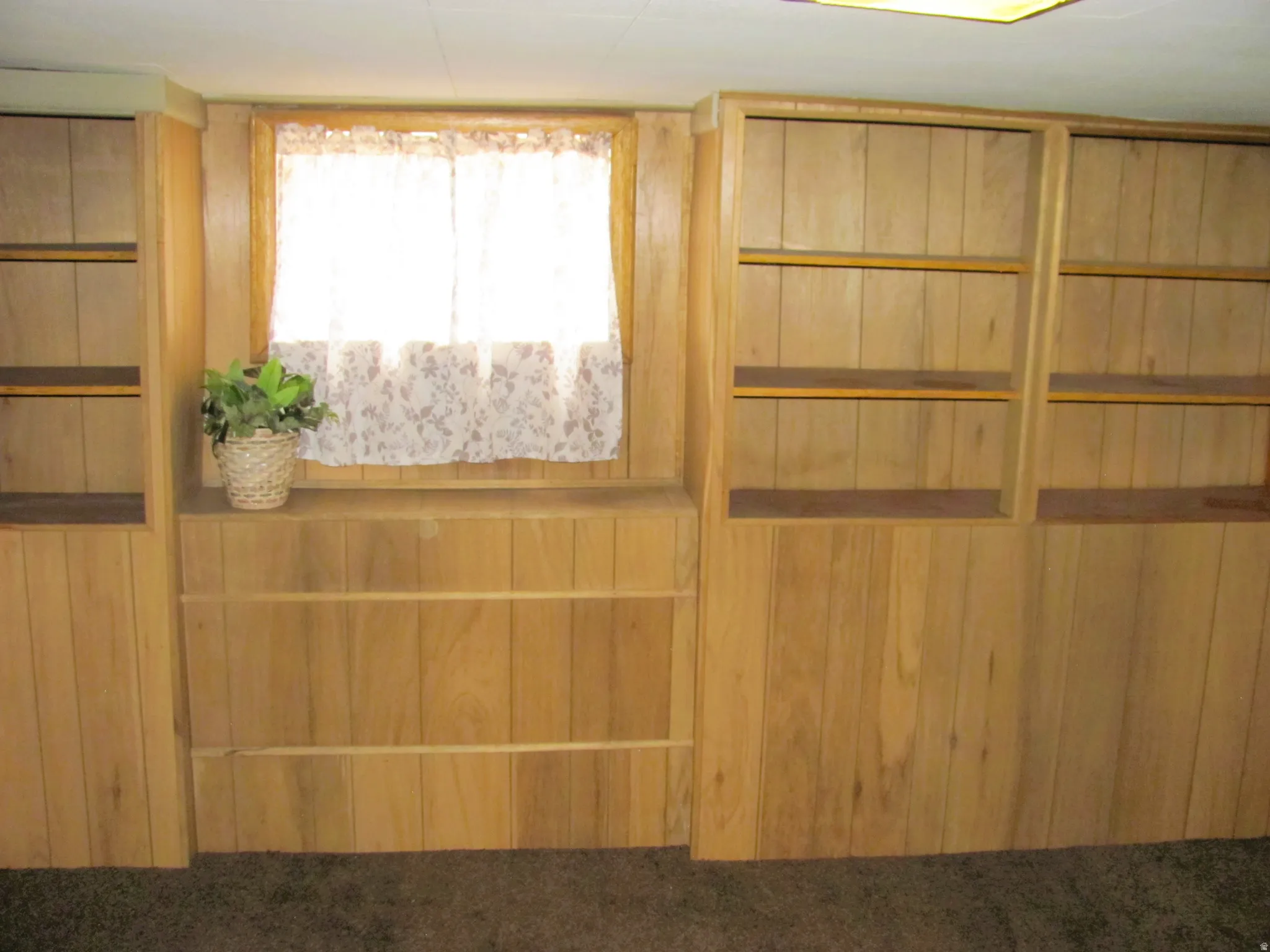 Interior space featuring extensive wood-finish paneling and built-in shelving units