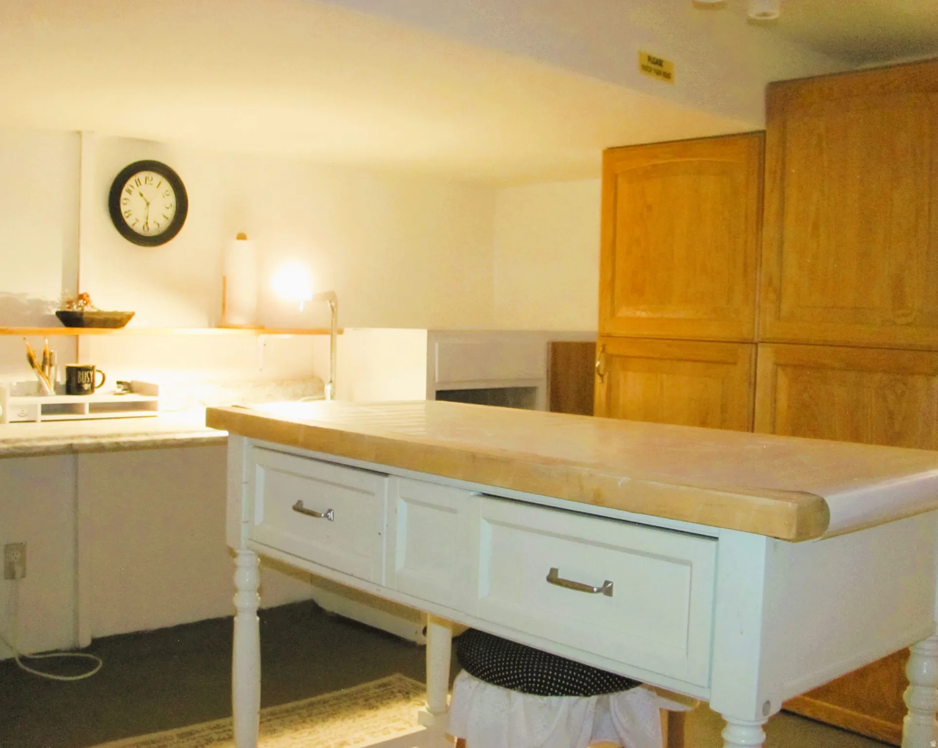 Freestanding island with a light wood countertop and two white drawers featuring silver-tone hardware