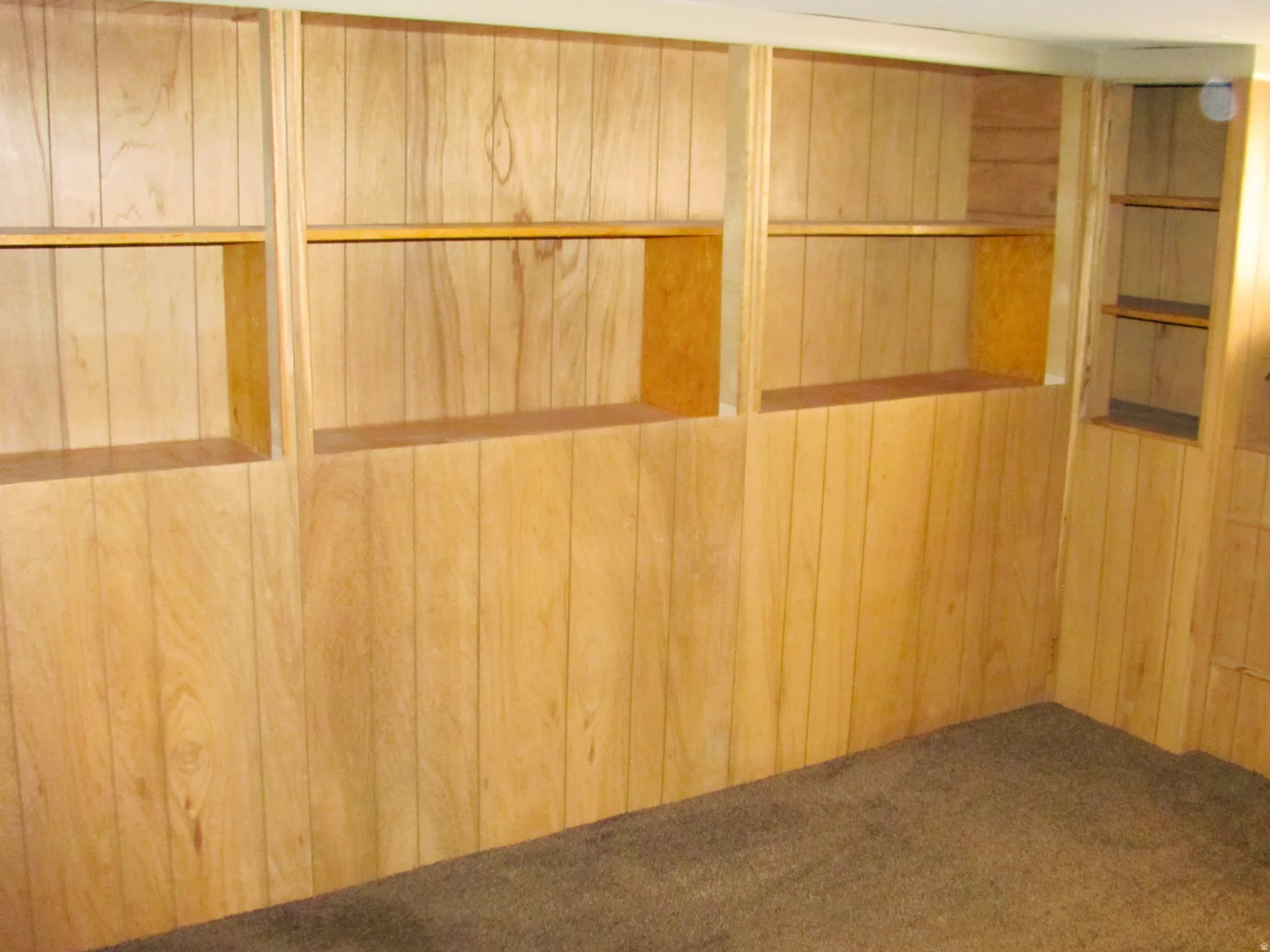 Wood-paneled wall with integrated shelving units