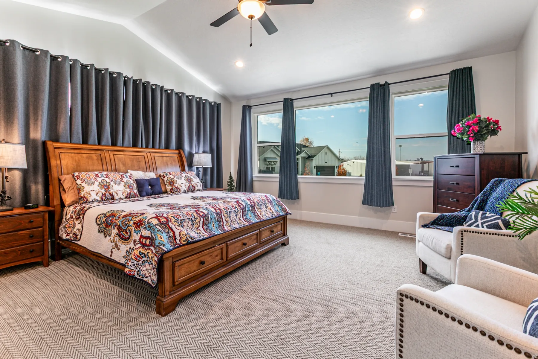 Vaulted ceiling with recessed lighting and a ceiling fan, broad windows, and carpeted flooring