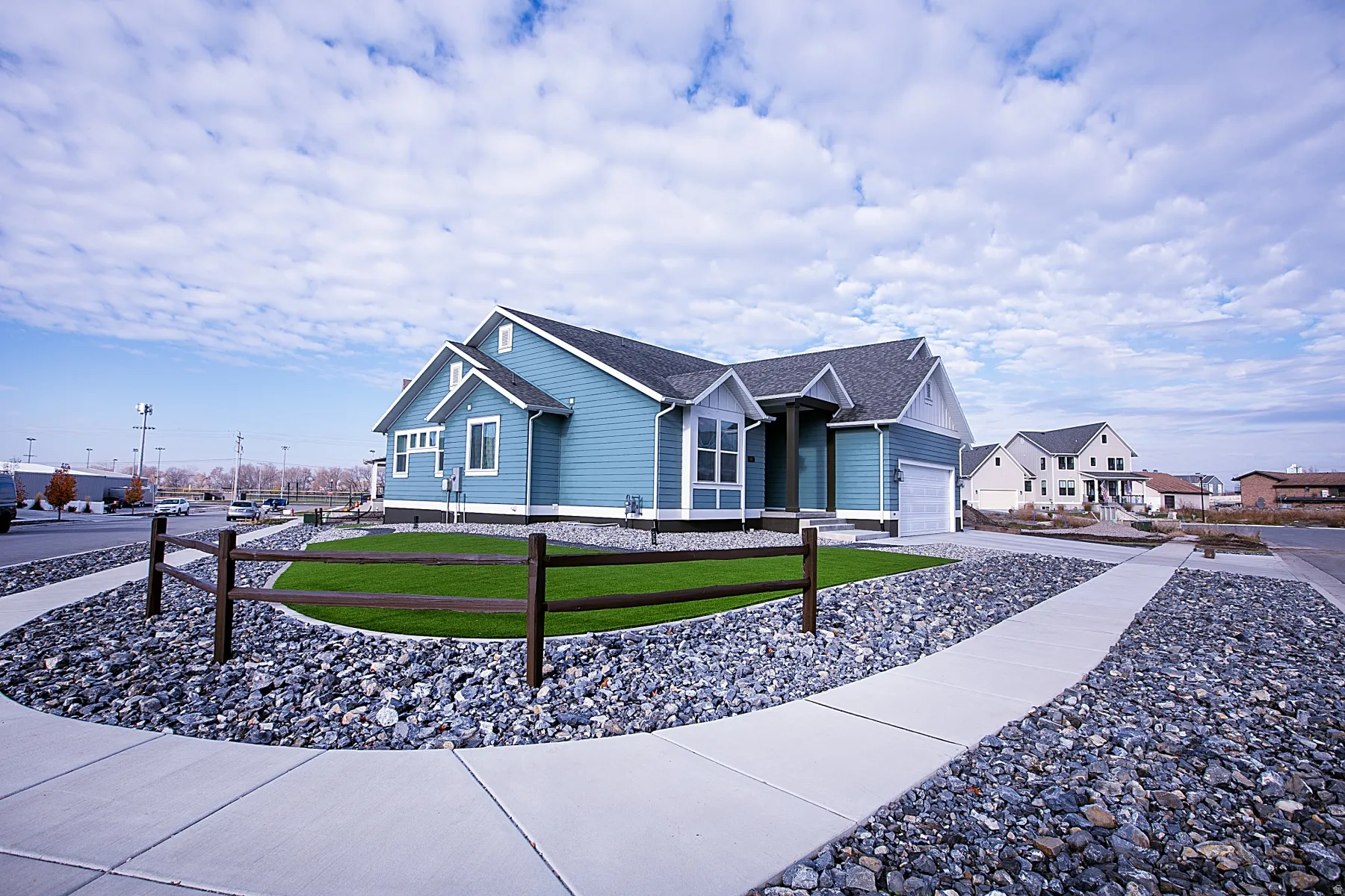 Single-story residence featuring light blue siding with white trim, a dark gray shingle roof, and an attached two-car garage