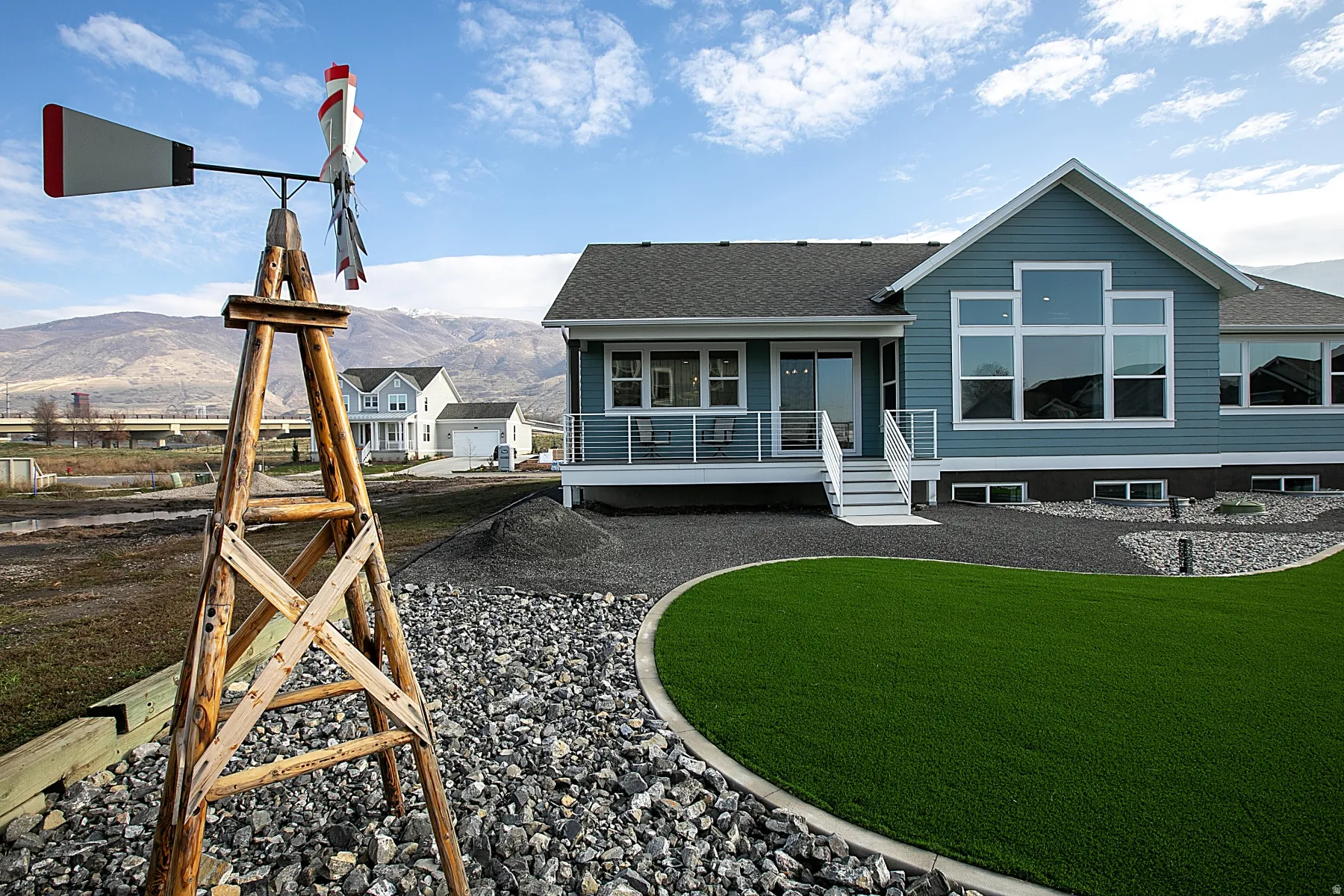 Exterior showcasing a blue-gray siding, a prominent multi-pane window configuration, and a durable dark roof