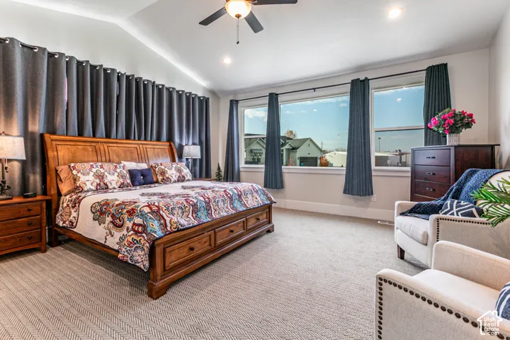 Vaulted ceiling with recessed lighting and a ceiling fan, broad windows, and carpeted flooring