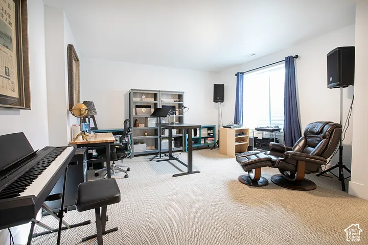 Spacious room featuring light-toned carpeting, ample natural light from a large window, and recessed ceiling lighting