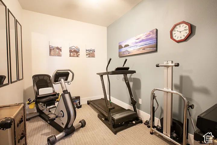 Carpeted interior room with light-colored walls and white trim