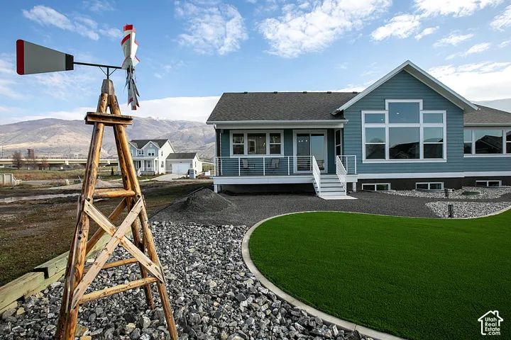 Exterior showcasing a blue-gray siding, a prominent multi-pane window configuration, and a durable dark roof