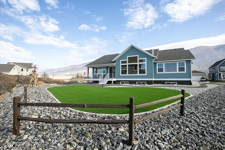 Turquoise siding with white trim accents and a dark roof