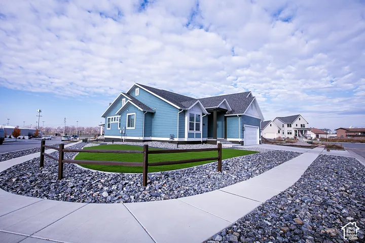 Single-story residence featuring light blue siding with white trim, a dark gray shingle roof, and an attached two-car garage