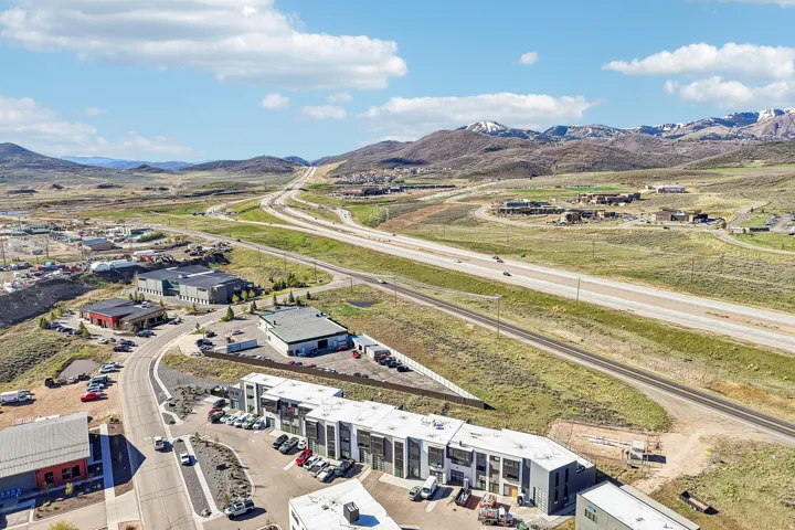 Aerial perspective showcasing multiple commercial buildings and a modern multi-unit structure