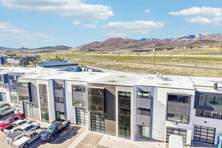 Modern multi-level townhomes featuring mixed-material facades with vertical siding and stucco