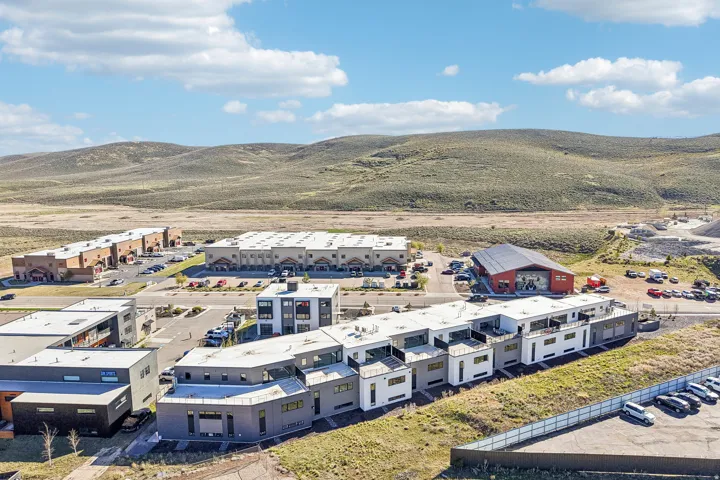 Modern multi-unit structures featuring flat roofs and varied exterior finishes