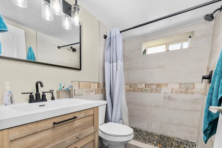 Bathroom featuring a wood-finish vanity with a white countertop and rectangular sink