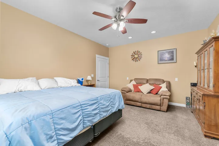 Spacious room featuring vaulted ceilings, recessed lighting, a ceiling fan, and plush carpeting
