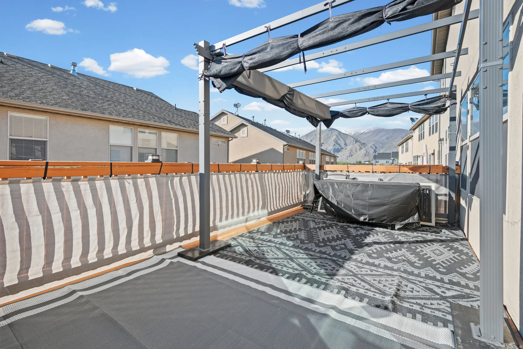 Outdoor patio featuring a grey metal pergola with black shading