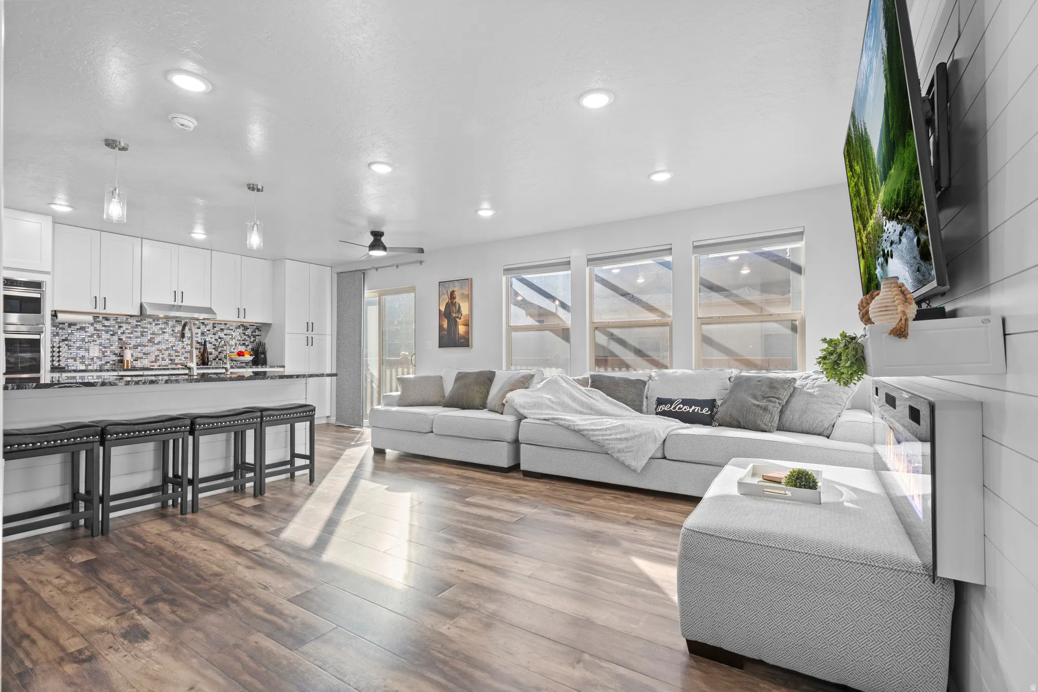 Open-concept living space featuring wood-finish flooring and recessed lighting