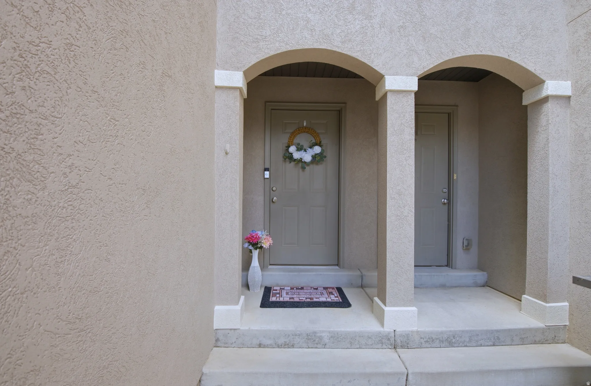Stucco exterior with arched entryway