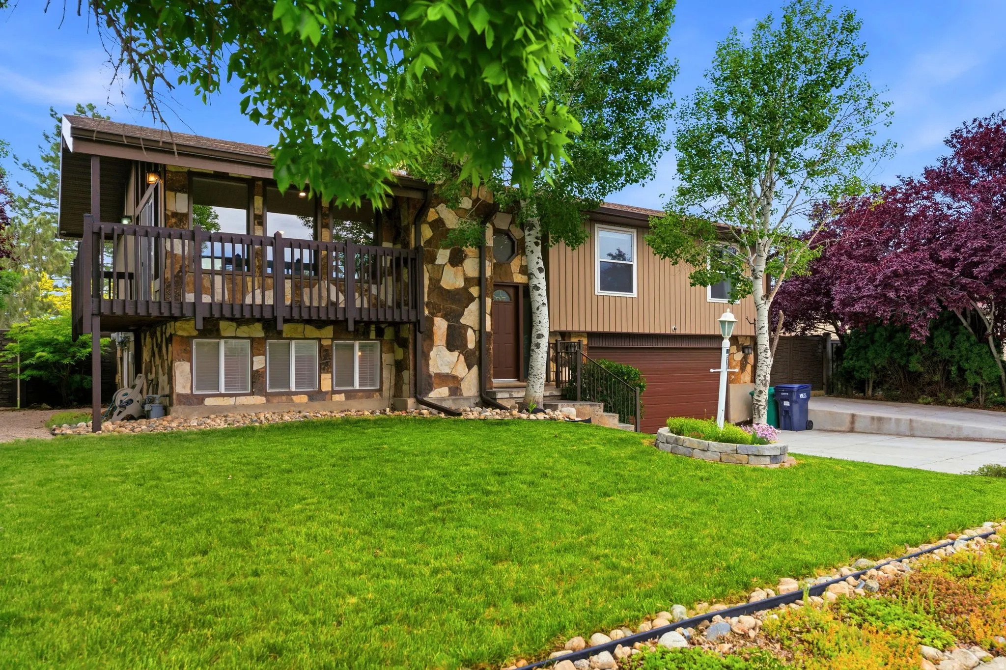 Split-level exterior featuring a stone and vertical siding facade