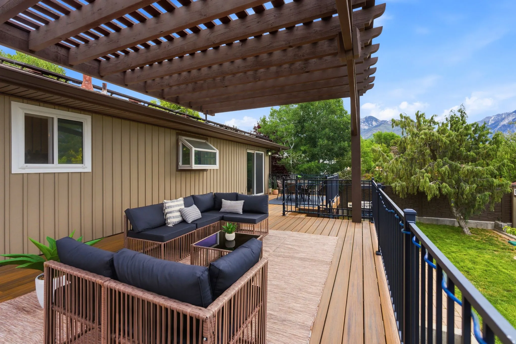 Expansive outdoor deck featuring wood-finish flooring and an overhead pergola