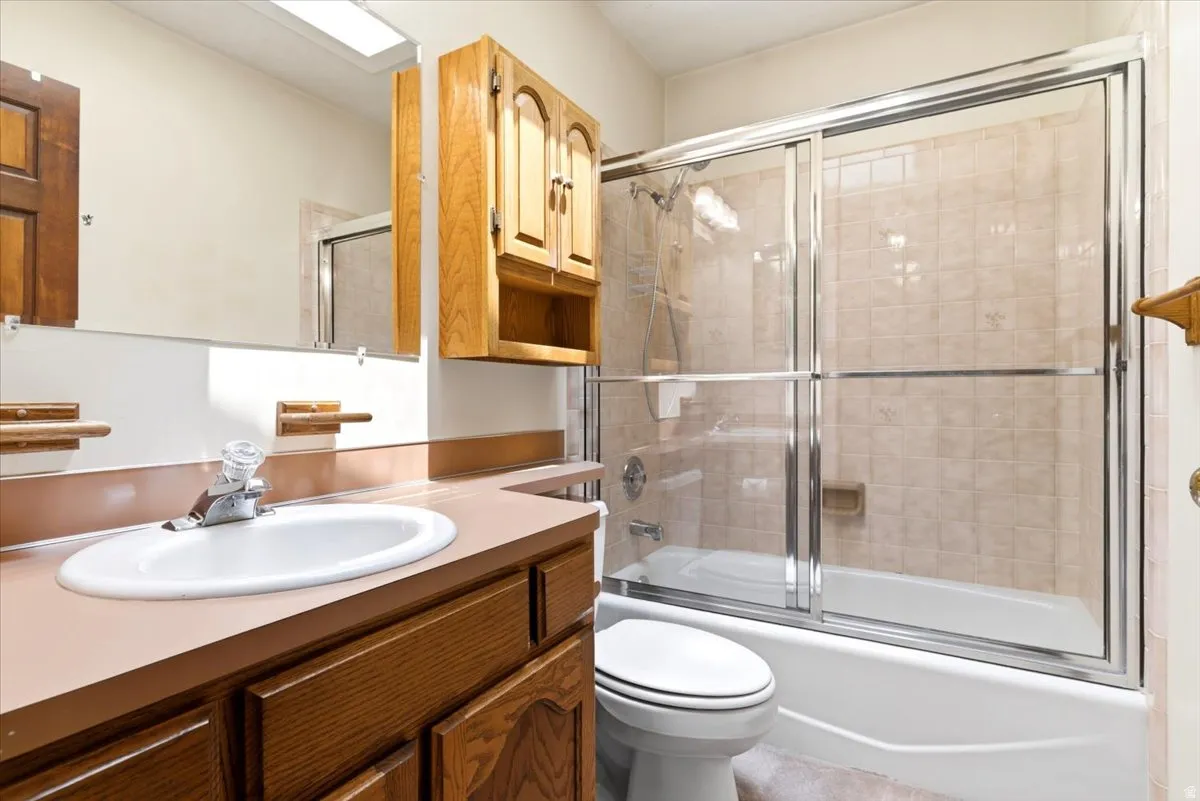 Bathroom featuring a built-in vanity with a white oval sink, wood cabinetry, and a laminate countertop
