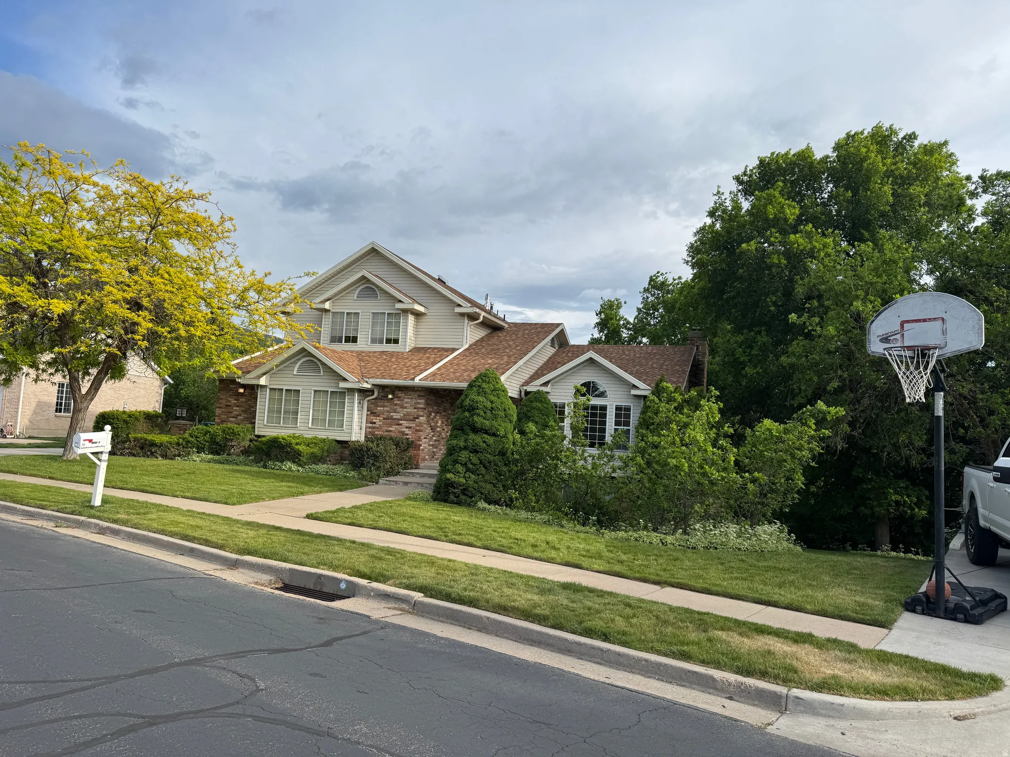 Traditional-style residence featuring brick and siding exterior, multi-pane windows, and a prominent gable roofline