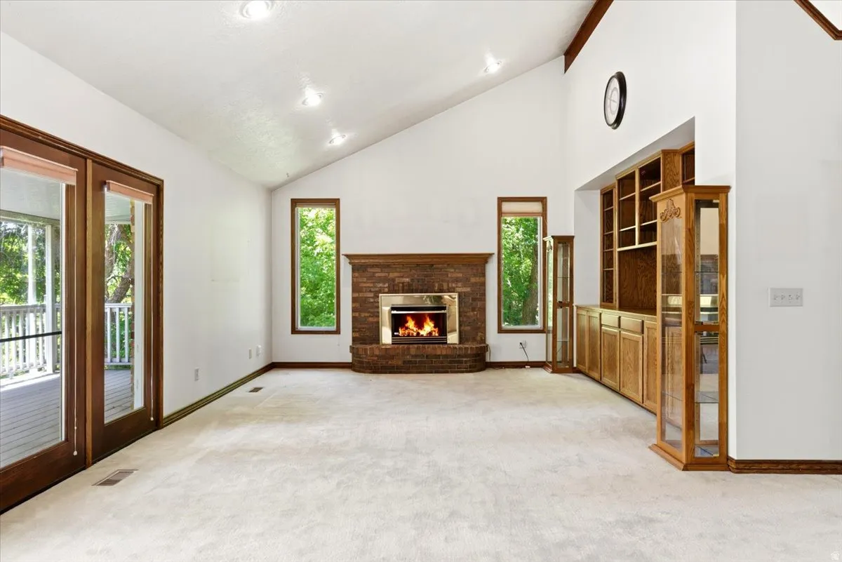 Spacious room featuring a vaulted ceiling and recessed lighting