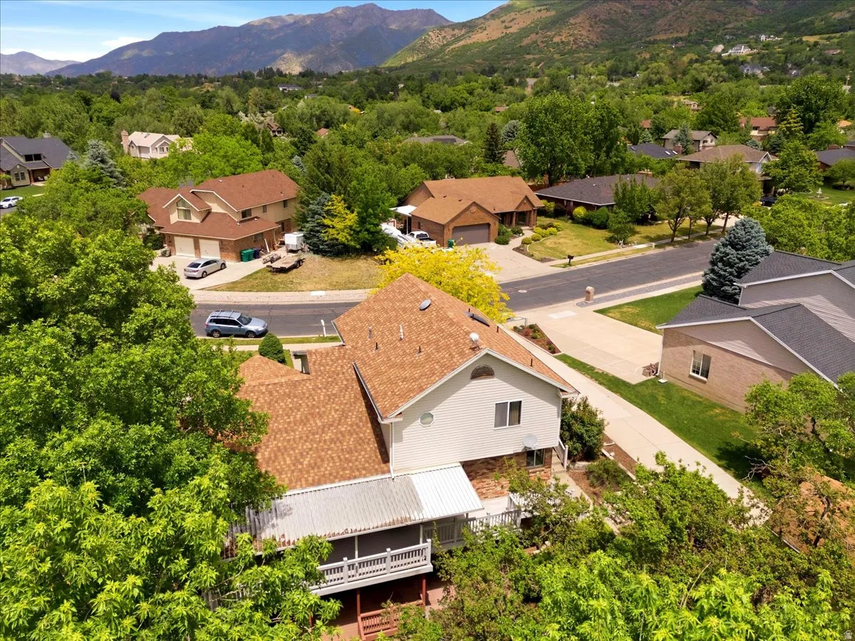 Two-story residence with a light-colored exterior and a brown shingle roof